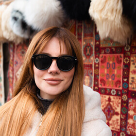 Woman standing outside a local shop in Baku Old City during a photo tour